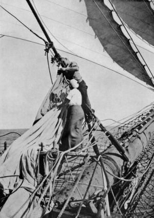 picture of two sailors - one female - changing the jib sail